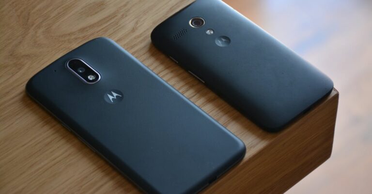 Two Motorola smartphones placed on a wooden table with natural lighting.